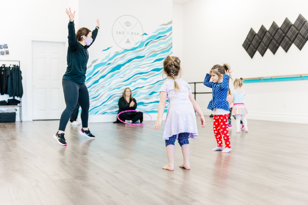 A woman leads a dance class of 4 toddlers