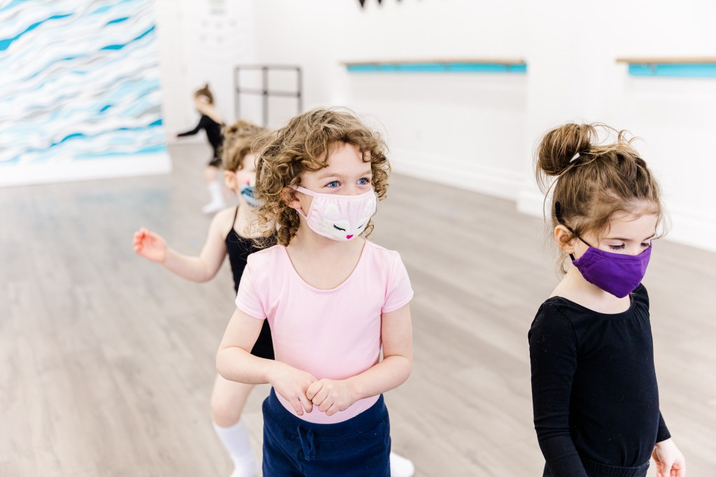 four children wearing face masks