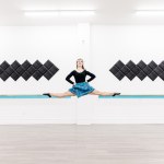 A dancer in a blue kilt does a jump