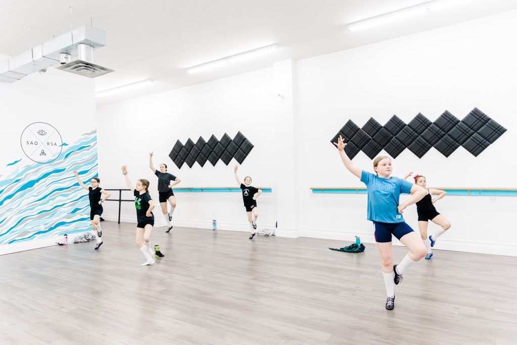 6 child dancers jump and pose in a white room