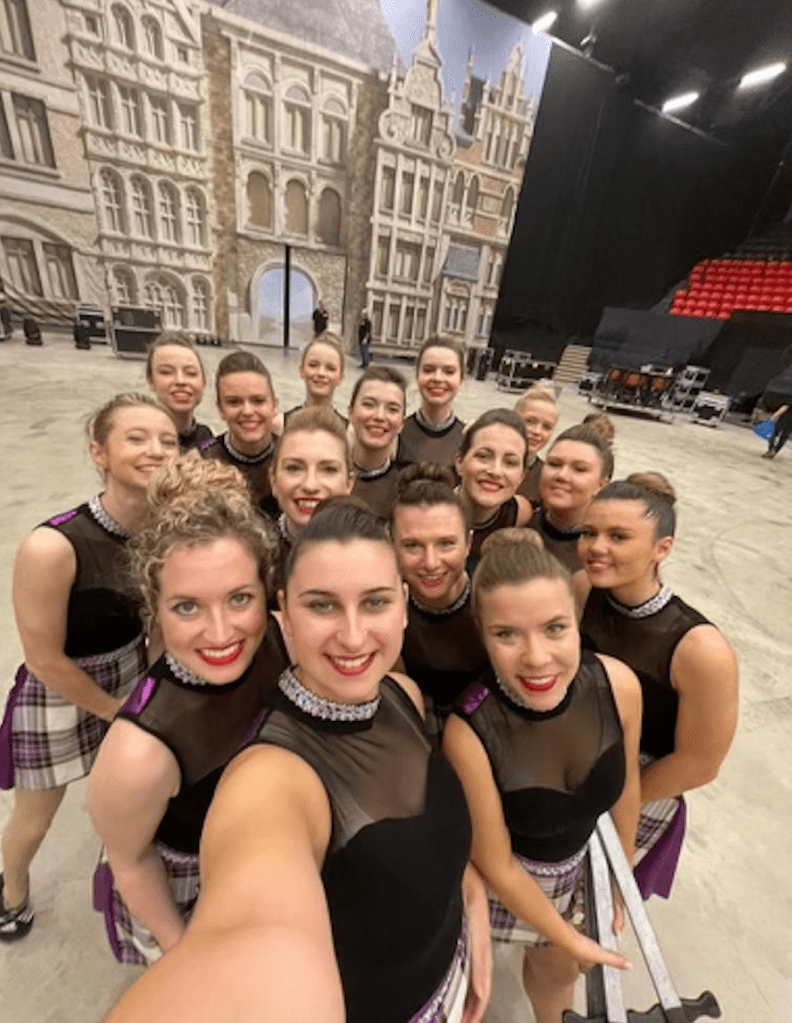 A selfie of smiling women in black tops