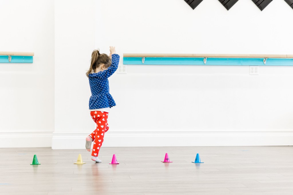A child plays with mini plastic cones