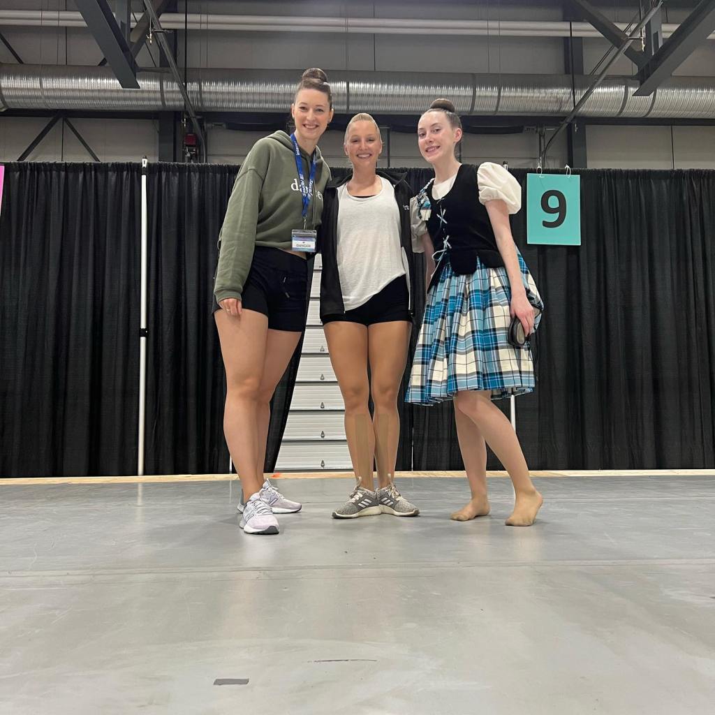 Three women smile and hug