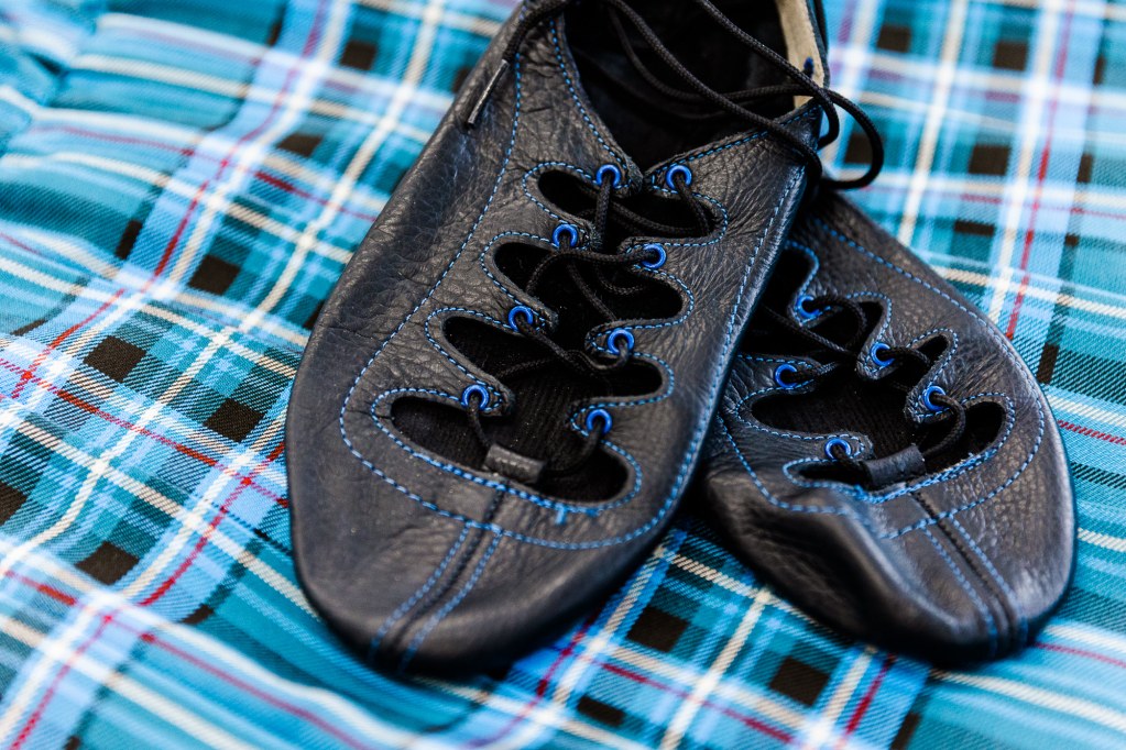 Black dance shoes on a blue plaid background