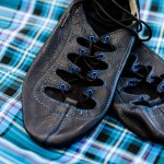 Black dance shoes on a blue plaid background