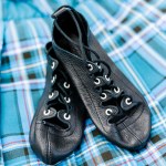 Black dance shoes on a blue plaid background