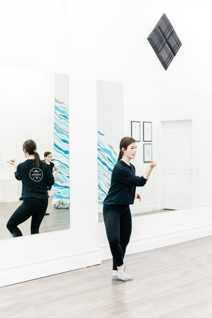 An instructor in a white room with a blue wall that reads "SAORSA"