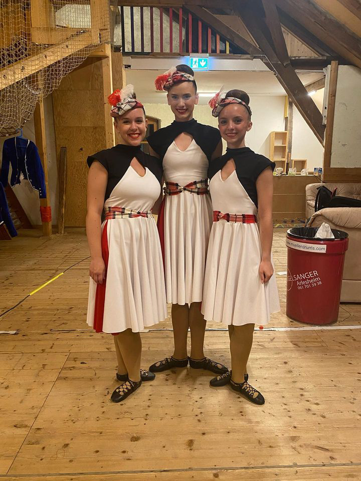 3 dancers pose in white dresses