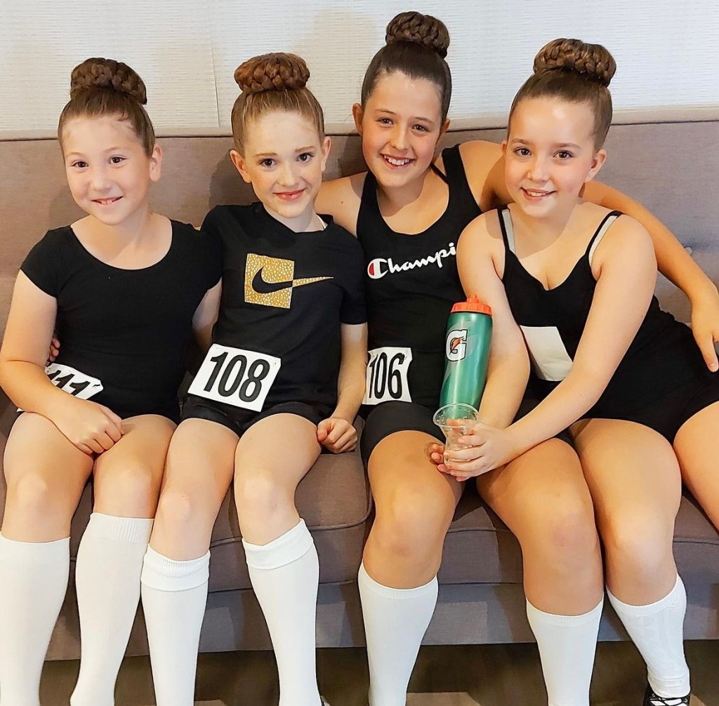 4 girls smile wearing black