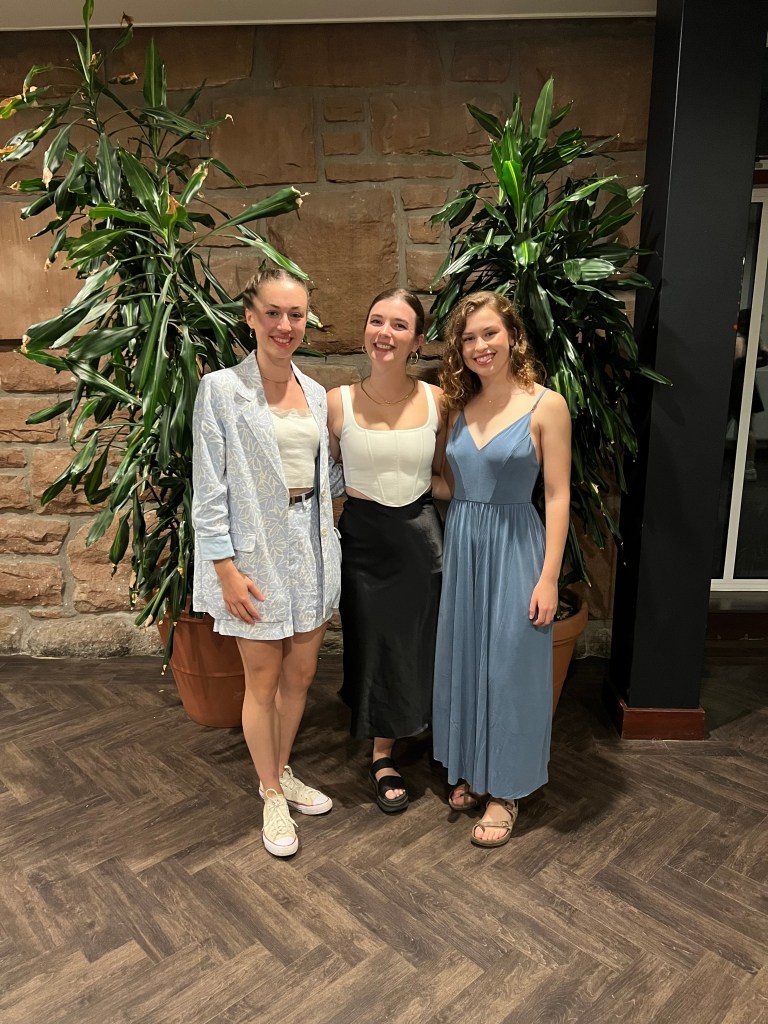 3 women smile and pose