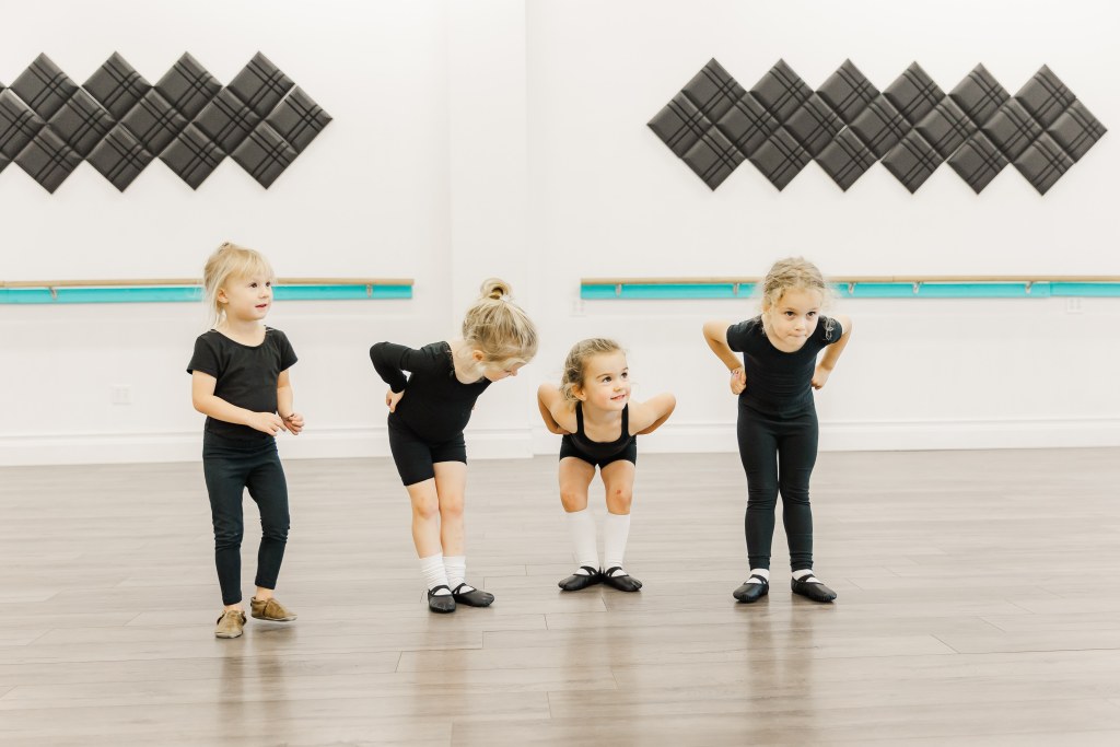 4 young dancers pose in a white room