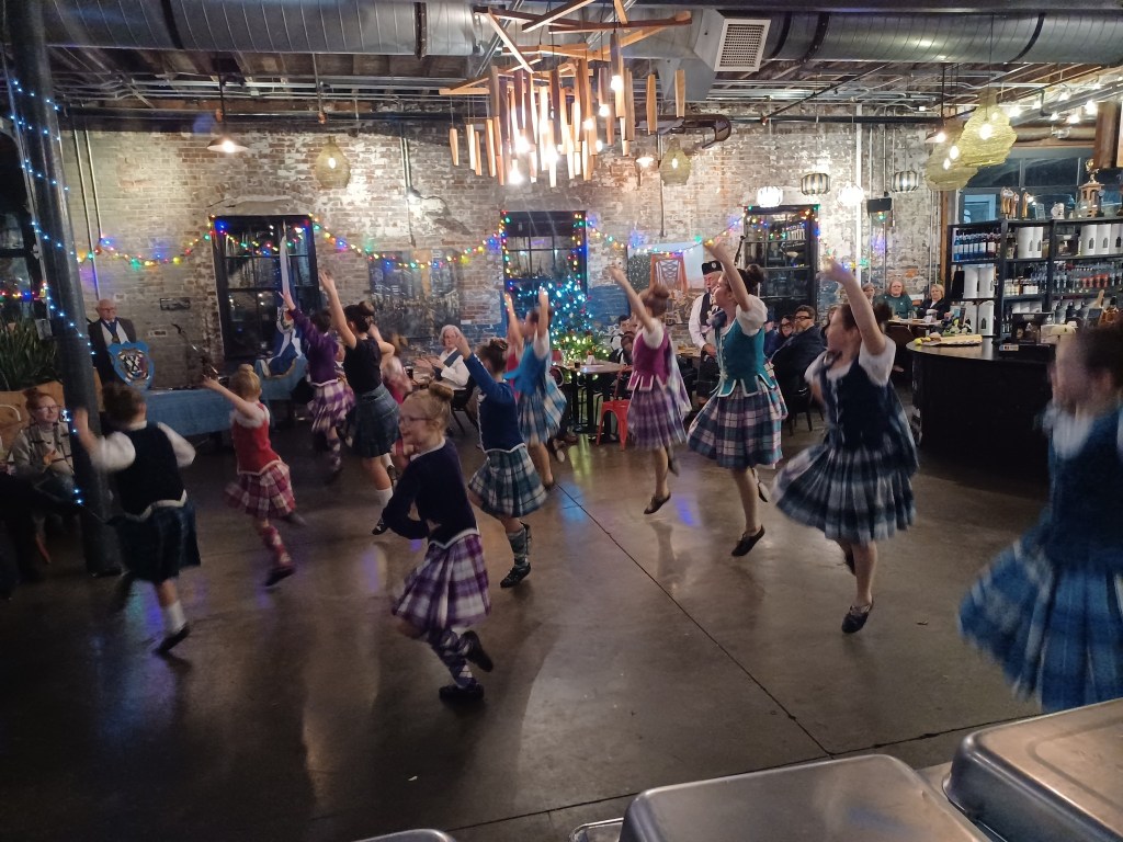 Dancers in kilts dance in a group