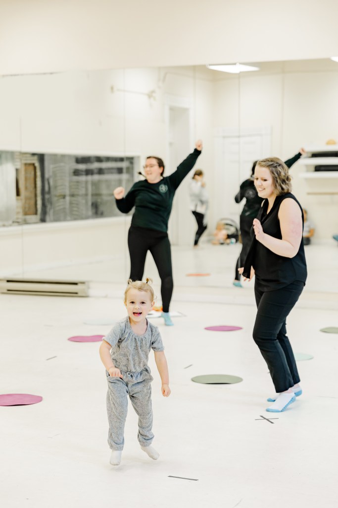 2 women and a child dance in a white room