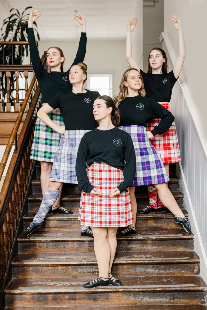 5 dancers pose on stairs