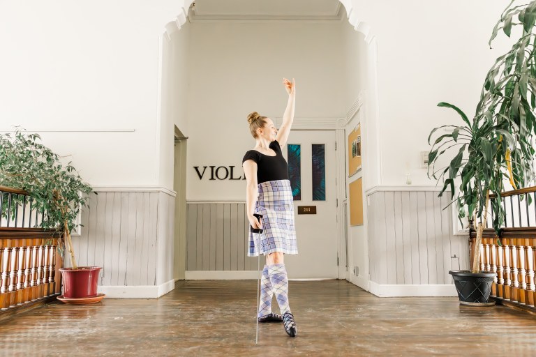A dancer poses in a hallway