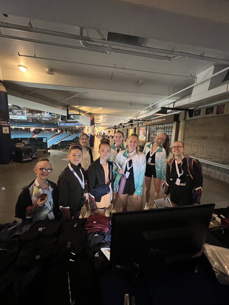 A photo of 8 women smiling and carrying bags