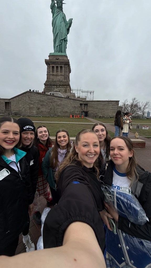7 Women smile in front of the Statue of Liberty. Saorsa Studio Highland Dance Fredericton.