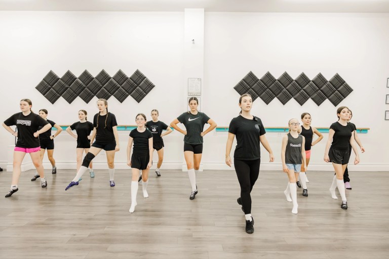 Young highland dancers wearing all black dance together in a class. The room is white. A dance instructor wearing black is at the front of the class. Saorsa Studio offers Highland Dance classes for ages 1 to adult in Fredericton, New Brunswick.