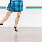 A highland dancer in a blue kilt demonstrates a Scottish dance movement. Saorsa Studio offers Highland Dance classes for ages 1 to adult in Fredericton, New Brunswick.